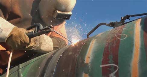 Person welding a pipeline