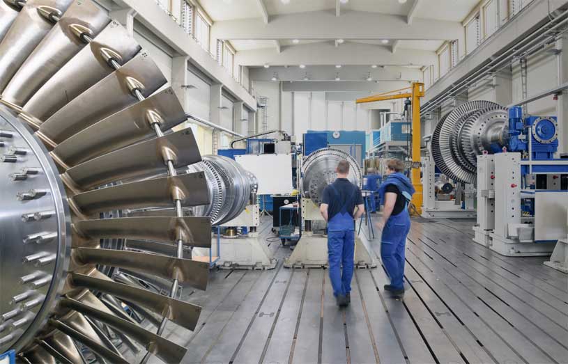 Workers near an airplane jet engine being built